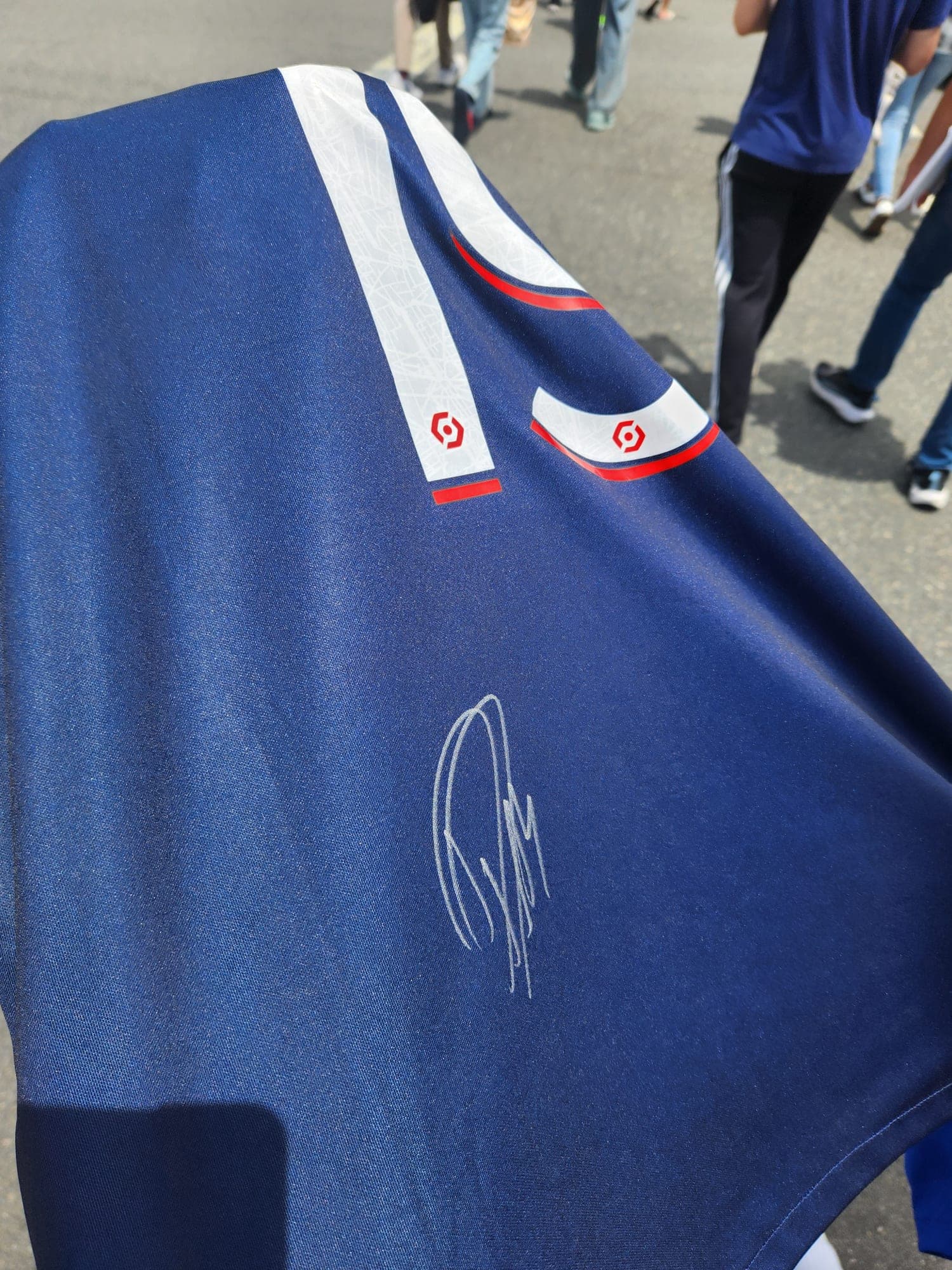 A navy Paris Saint-Germain shirt with a silver signature across the front